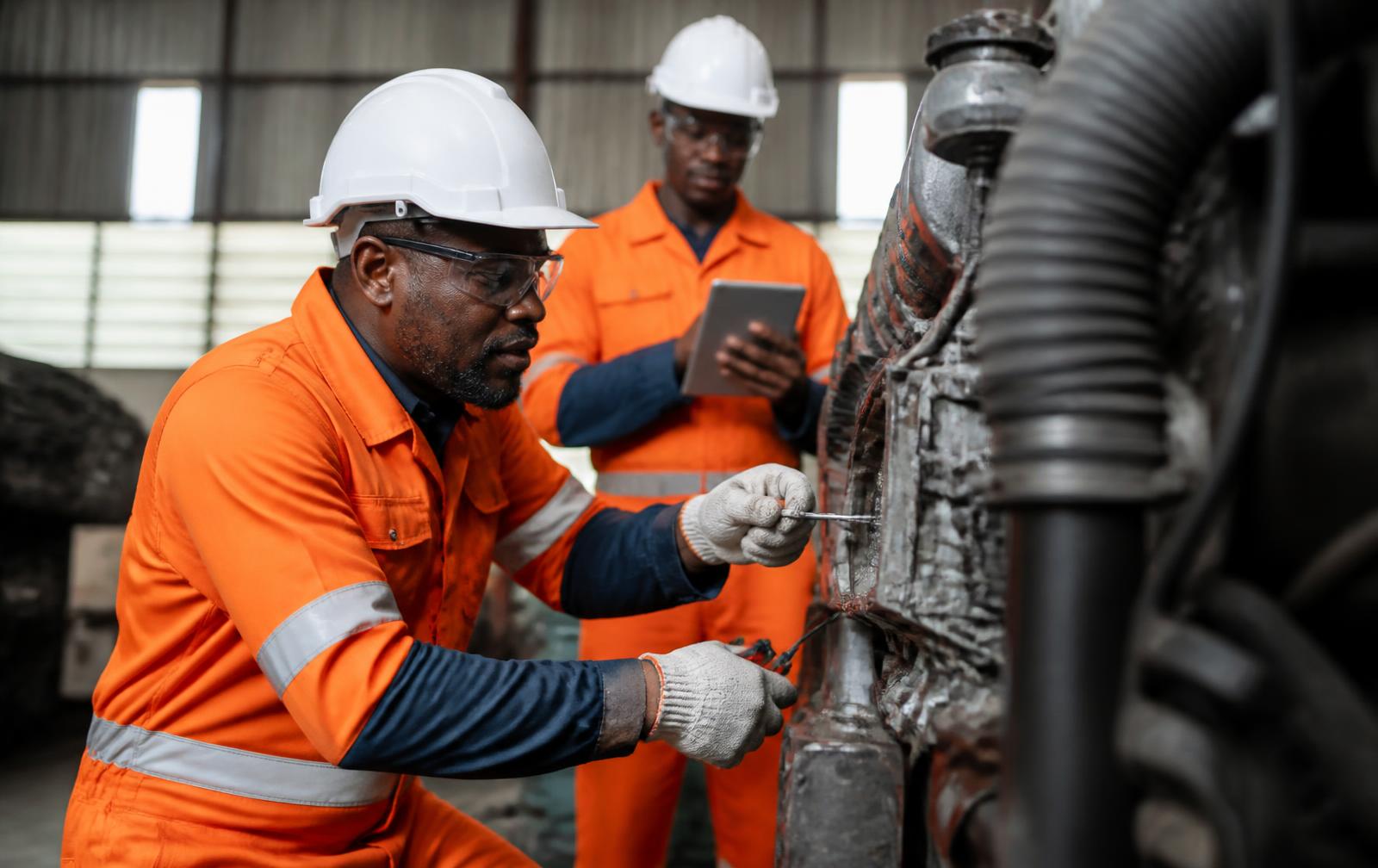 Techniciens de maintenance africains réparant une machine industrielle